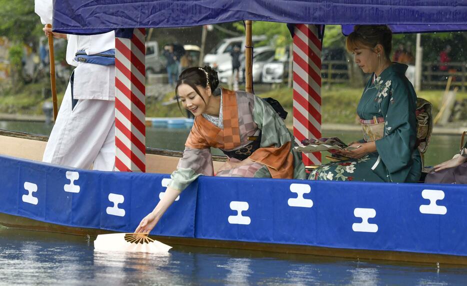 京都・嵐山で行われた「三船祭」で、川面に扇を浮かべる俳優の観月ありささん＝19日午後