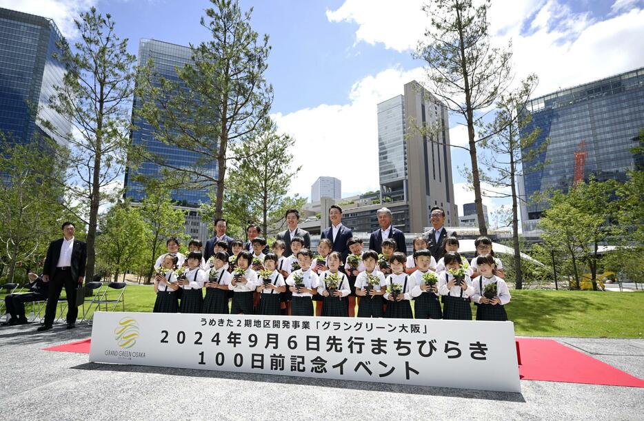 JR大阪駅北側の再開発区域「うめきた2期」の先行街開きまで100日の記念イベントで、写真に納まる大阪府の吉村洋文知事（後列左から3人目）ら＝29日午前