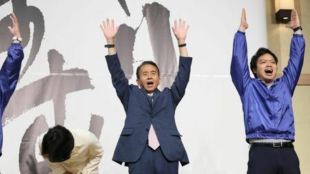 静岡県知事選で当選確実の報道を受け、万歳する鈴木康友氏（写真：時事）