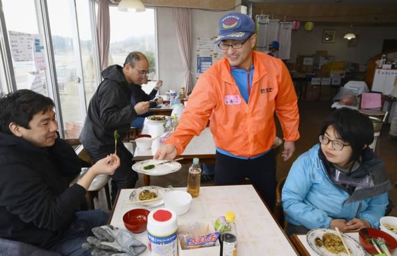 自主避難所となっている「珠洲市自然休養村センター」で、ボランティアに地元の食材を用いた料理を振る舞う小秀一さん（右から２人目）＝２０２４年３月