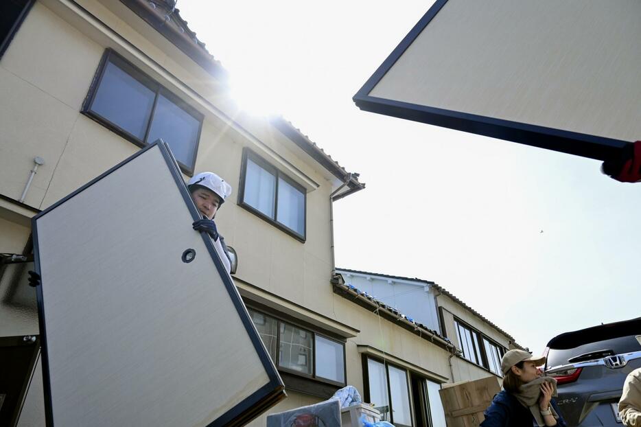 能登半島地震で被害を受けた石川県輪島市の家屋から、ふすまを運び出すボランティア＝5日午後