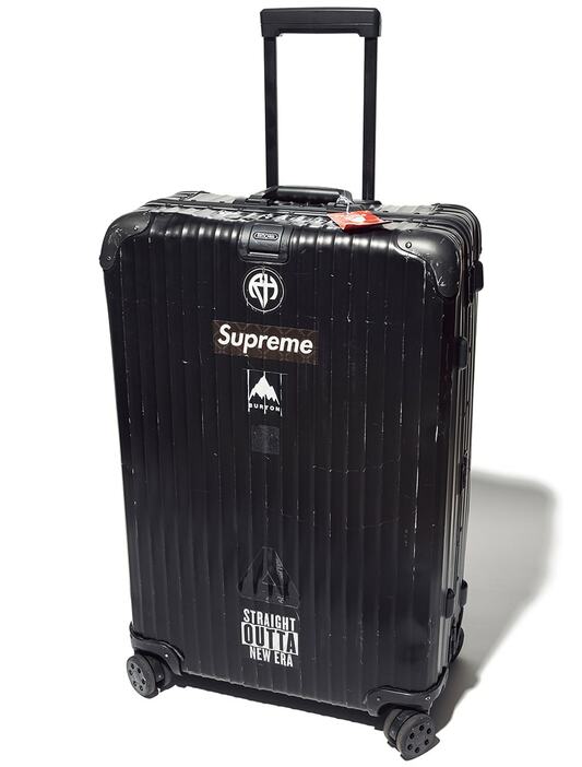 「リモワ」のスーツケース。購入した12年ほど前は、まだ珍しかったアルミ仕様のオールブラック。ステッカーチューンもモノトーンで。