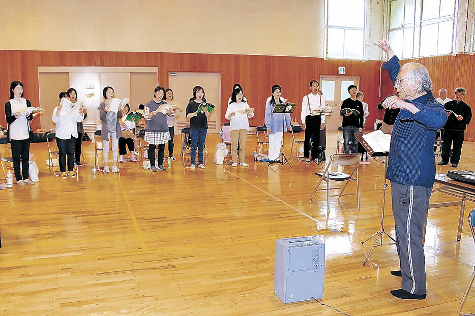 山瀬さん（右）の指導で、被災地を思う合唱曲を練習する泰声会＝白山市の石川県白山青年の家