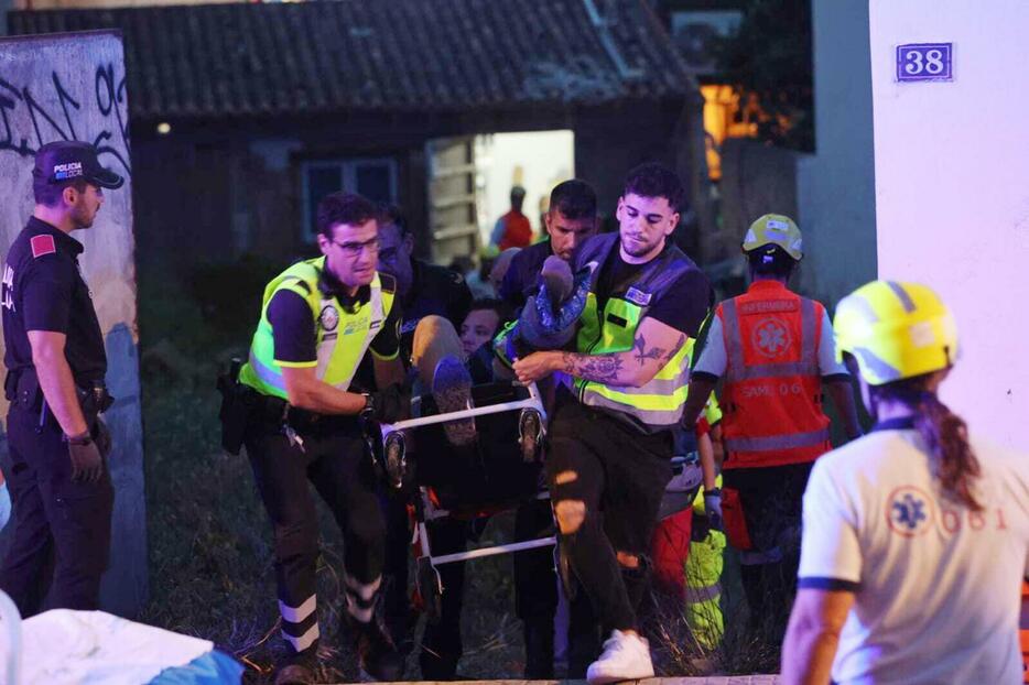 倒壊した建物から負傷者を運び出す医療関係者ら＝23日、スペイン・パルマデマジョルカ（AP＝共同）