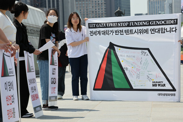 パレスチナ国旗の色のテントが描かれた横断幕に韓国語、英語、日本語、中国語などで反戦メッセージが記されている=キム・ヨンウォン記者
