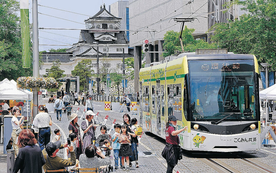 市内電車と大勢の家族連れらでにぎわう通り＝富山市の大手モール