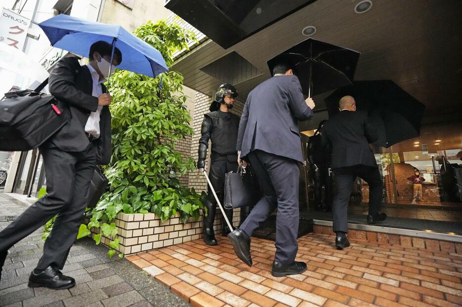 家宅捜索のため、つばさの党の事務所がある建物に入る捜査関係者＝13日午前11時8分、東京都千代田区