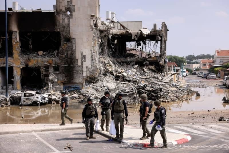 イスラエル南部スデロトで、ハマスとの戦闘があった地域に集まる治安当局者ら＝２０２３年１０月８日（ロイター＝共同）