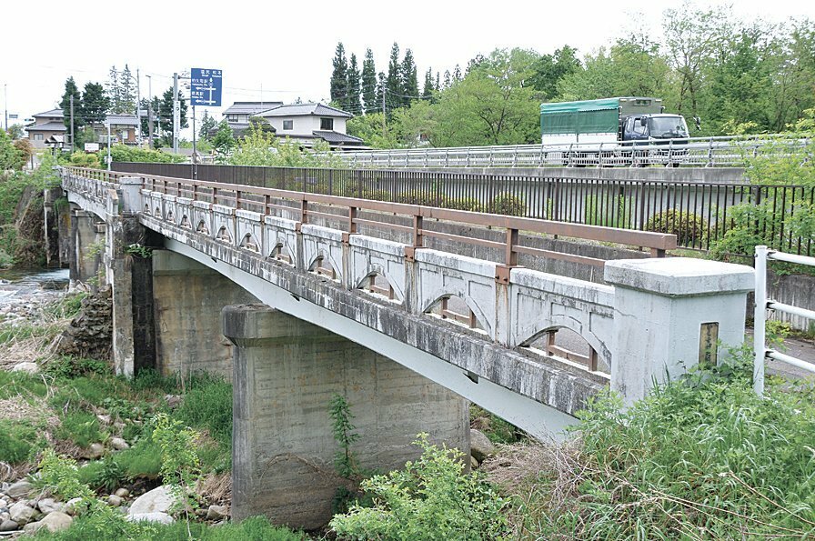 烏川橋の歩道橋。手前が延伸された部分。橋の中ほどに当時の親柱の一部が残る