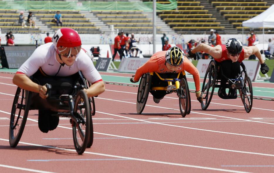 男子100メートル（車いすT52）決勝　3位でゴールする佐藤友祈（中央）。手前は優勝したマキシム・カラバン＝神戸ユニバー記念競技場
