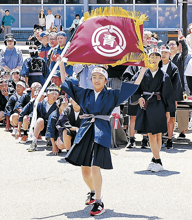 躍動的に旗を振る子ども旗手＝ＩＲ美川駅前