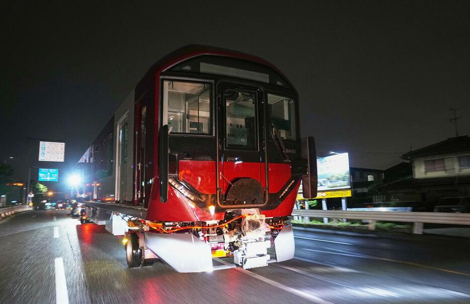 大型トレーラーに載せられ、市街地を通る近鉄の新型車両＝31日未明、大阪府八尾市