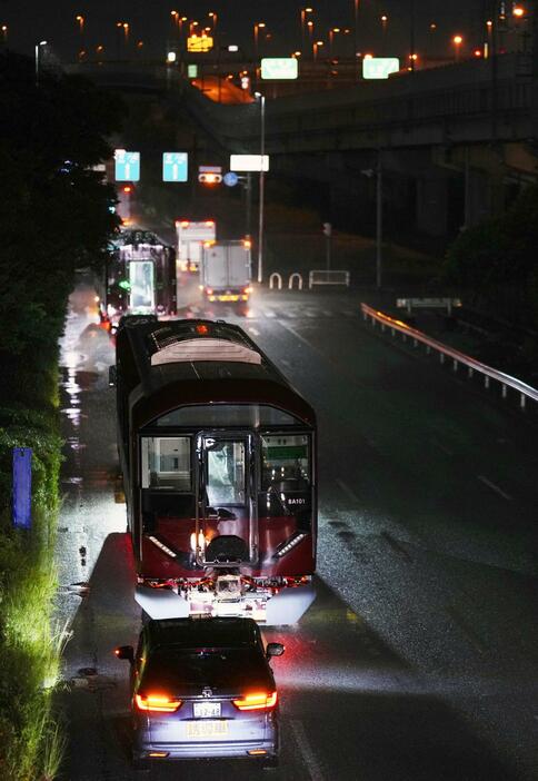 大型トレーラーに載せられ、真夜中の道路を通る近鉄の新型車両＝31日未明、大阪府東大阪市