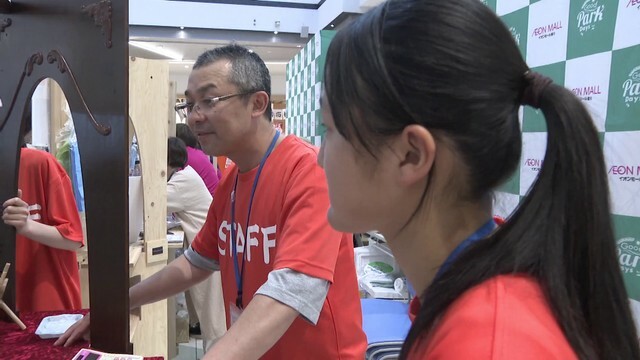 中学生と一緒に屋台を出す老津木工の松井誠さん