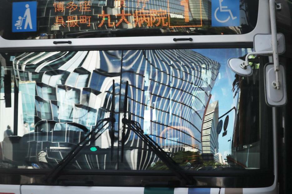 バスのフロントガラスに映る天神ビジネスセンターの壁面