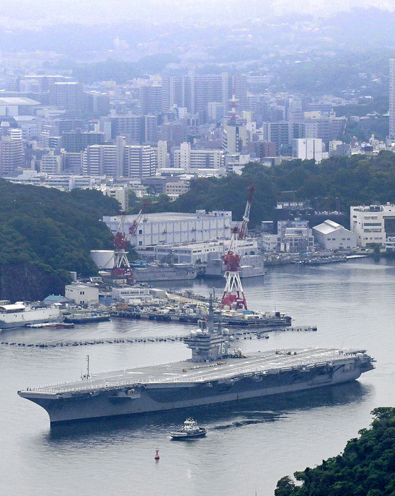 米海軍横須賀基地での任務を終え、出港する原子力空母ロナルド・レーガン＝16日午前10時36分、神奈川県横須賀市（共同通信社ヘリから）