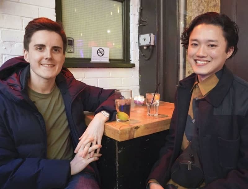 ２人が出会ったロンドンのバーで取材に応じるＫａｎさん（右）とトムさん＝２月（共同）