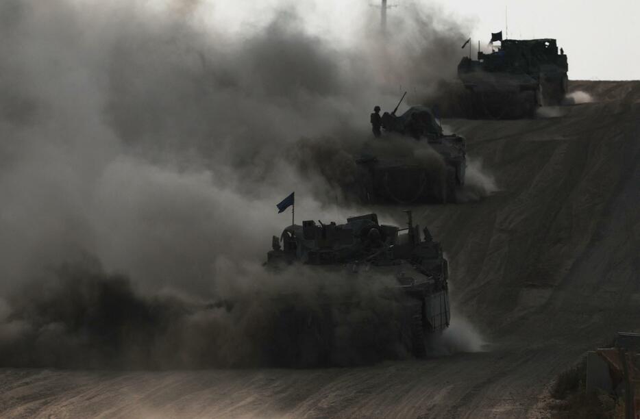 29日、イスラエル南部でガザ地区との国境付近を移動するイスラエル軍の輸送車（ロイター＝共同）