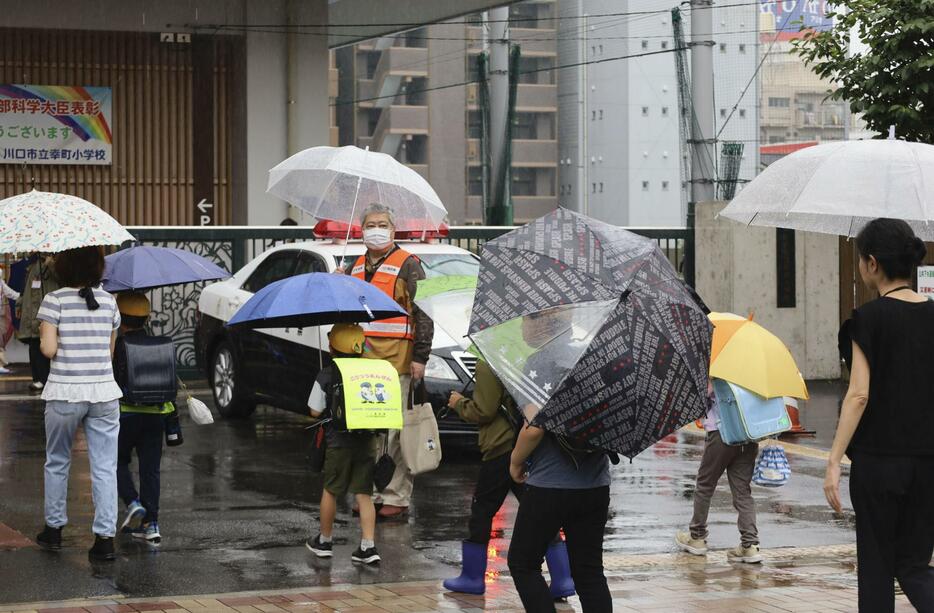 保護者らに付き添われ、集団登校する川口市立幸町小学校の児童＝31日午前8時ごろ、埼玉県川口市