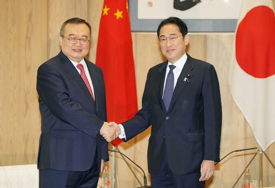 中国共産党の劉建超・中央対外連絡部長（左）と握手する岸田首相＝29日午前、首相官邸