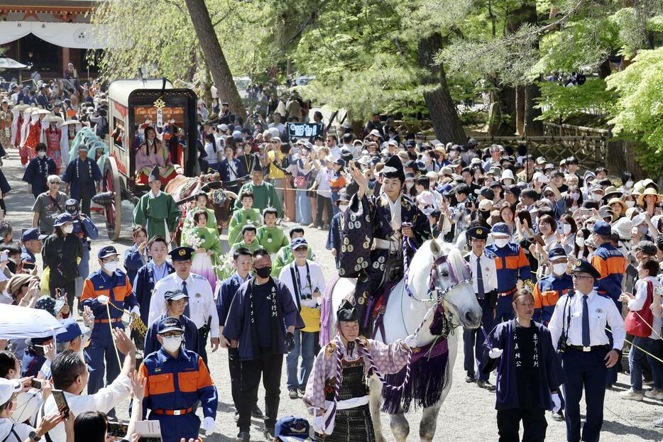 「源義経公東下り行列」で白馬にまたがり、手を振る源義経役の寺田心さん＝3日午後、岩手県平泉町