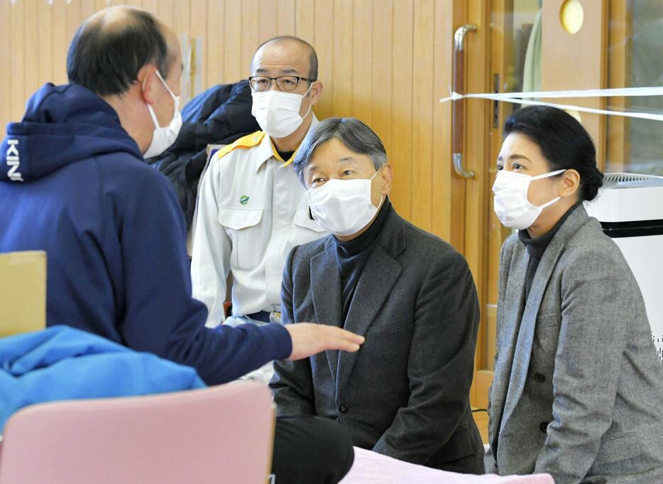 能登半島地震の避難所「輪島市ふれあい健康センター」を訪問し、被災者（左端）に声をかけられる天皇、皇后両陛下＝2024年3月22日午後、石川県輪島市（代表撮影）