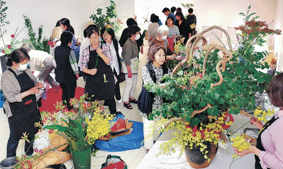 出品者らの熱気に満ちた前期の生け込み会場＝金沢市の香林坊大和８階ホール