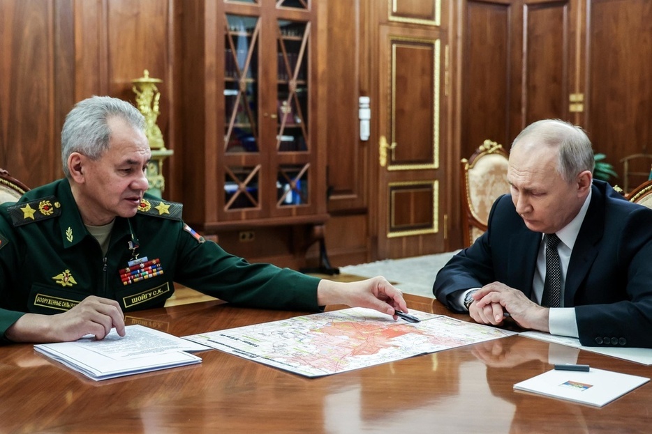 2月、モスクワの大統領府でショイグ国防相（左）と会談するロシアのプーチン大統領（ロシア大統領府提供・タス＝共同）