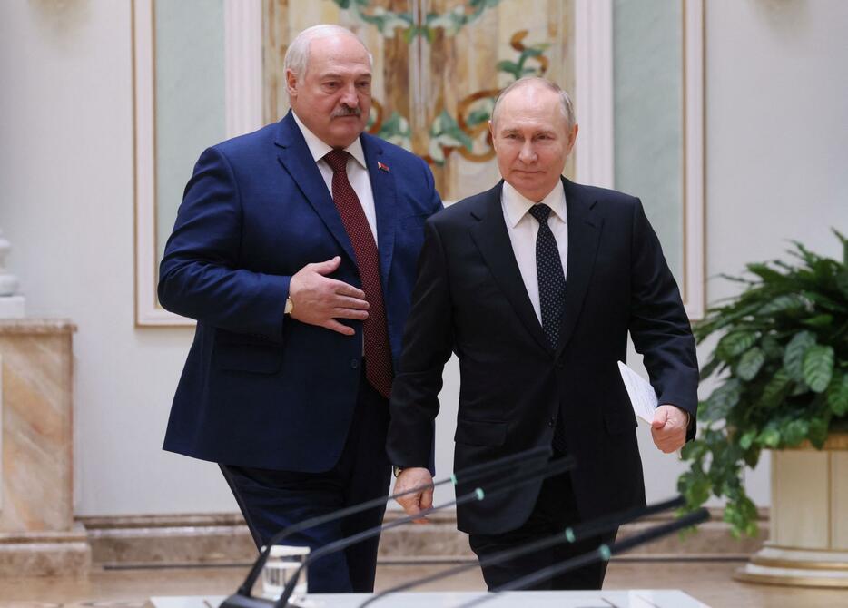 24日、ベラルーシの首都ミンスクで、ルカシェンコ大統領（左）と記者会見に臨むロシアのプーチン大統領（ロイター＝共同）
