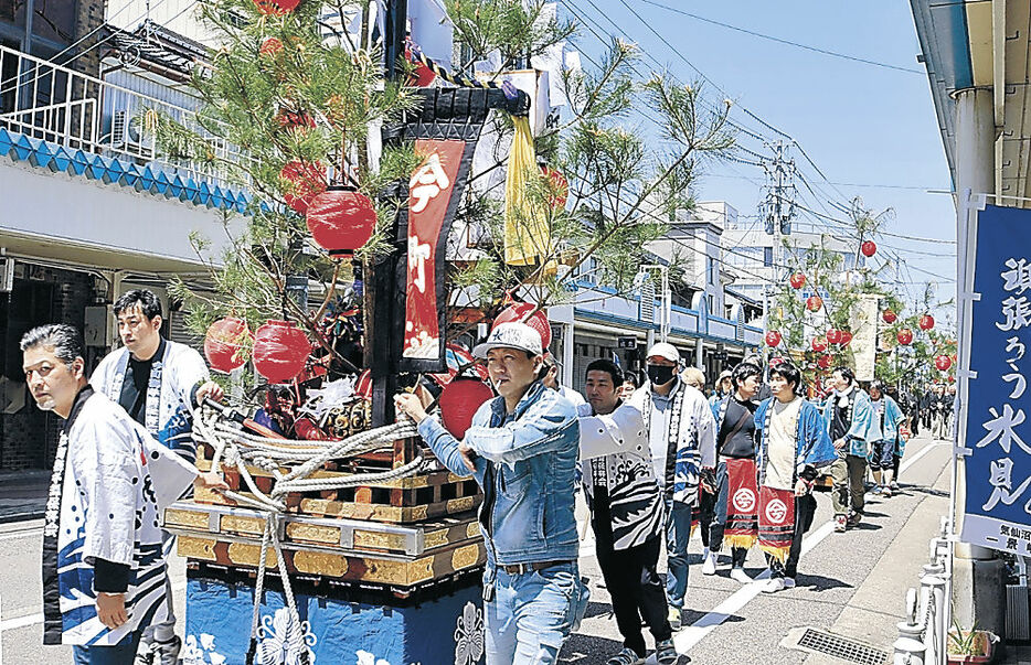 市街地をにぎやかに巡行する関係者＝氷見市比美町