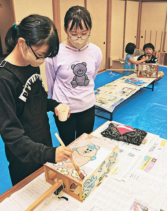 トッペ行燈に色を塗る児童（左）=種田コミュニティセンター