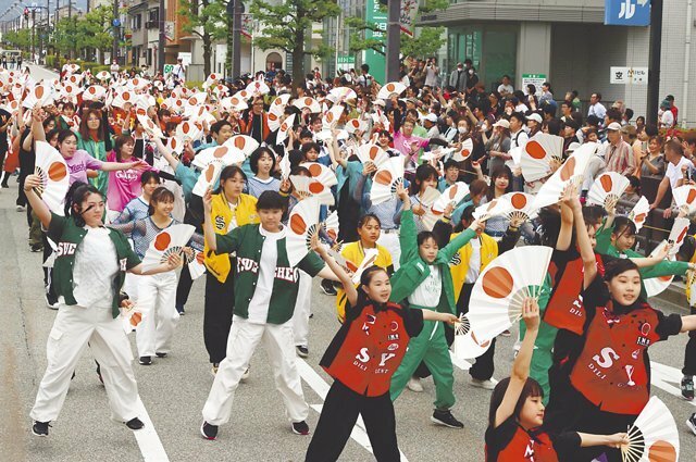 総踊りを披露する参加者たち＝魚津駅前通り
