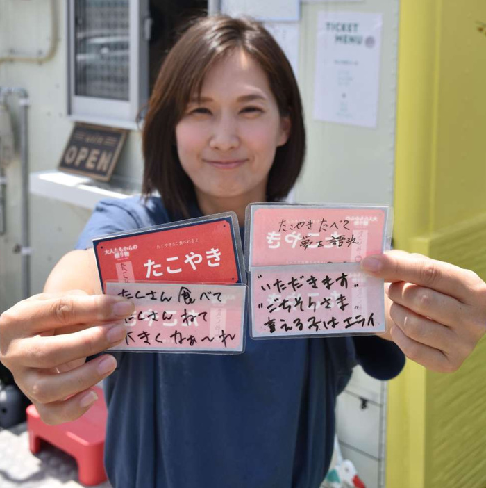 「未来チケット」を手に笑顔を見せる永松里美さん＝いちき串木野市照島