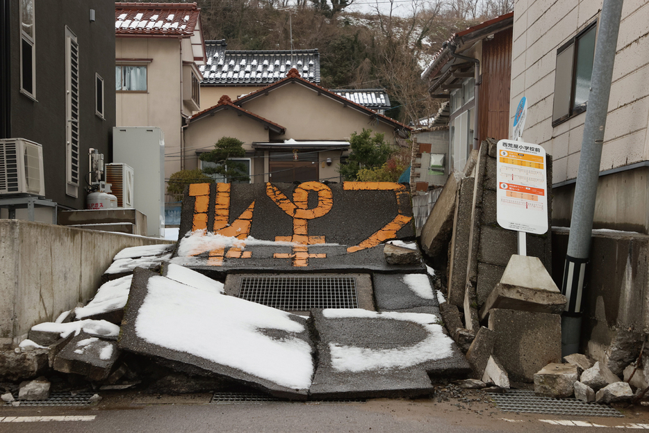 能登半島地震により地割れし、隆起した石川県内灘町の路面。共助や自助が不可欠だ（JIJI）