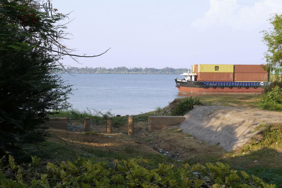 拡張工事が予定されるメコン川沿いの水路（手前）＝4月、カンボジア首都プノンペン近郊（共同）