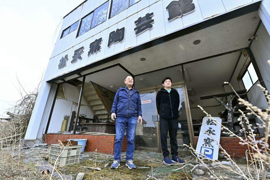 大堀相馬焼の窯元「松永窯」の店舗前に立つ松永武士さん（右）と父和生さん＝2024年3月、福島県浪江町