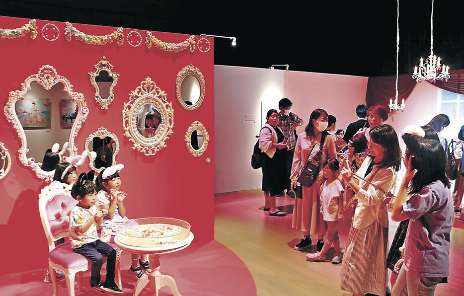 華美なバロック様式の「鏡の間」で記念撮影を楽しむ親子連れら来場者＝氷見市芸術文化館