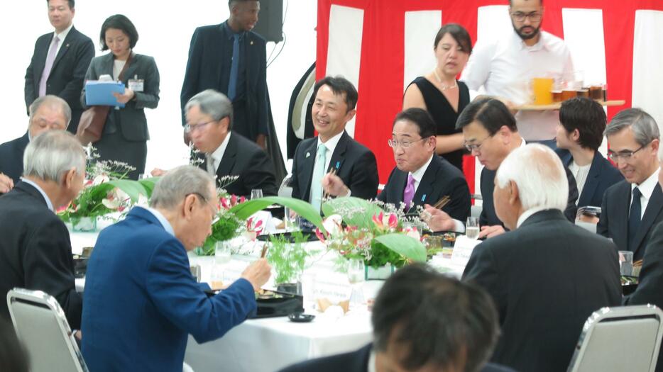 林禎二大使から説明を受けながら、美味しそうに弁当を食べる岸田総理