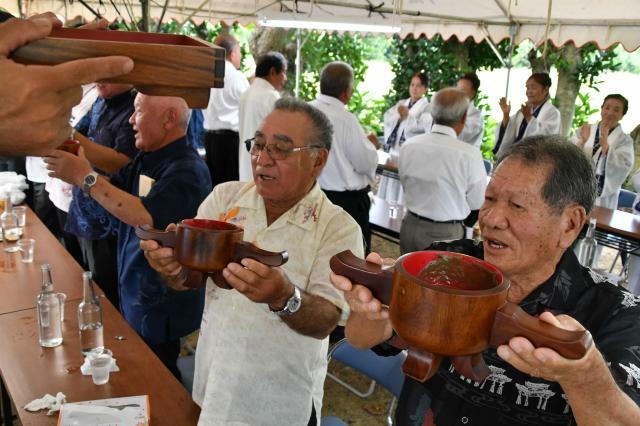 「ヤッカ、ヤッカ」のはやしを響かせ、角皿で神酒を回し飲む参加者ら＝29日、多良間村・ナガシガーの祭場