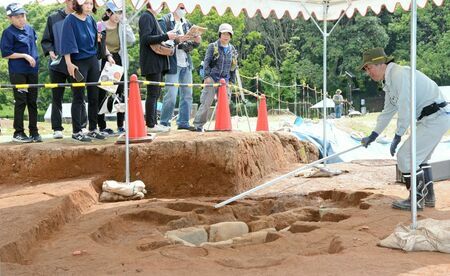 最後の公開となる石棺墓を訪れた見学者。職員の説明に聞き入った＝神埼市郡の吉野ケ里遺跡