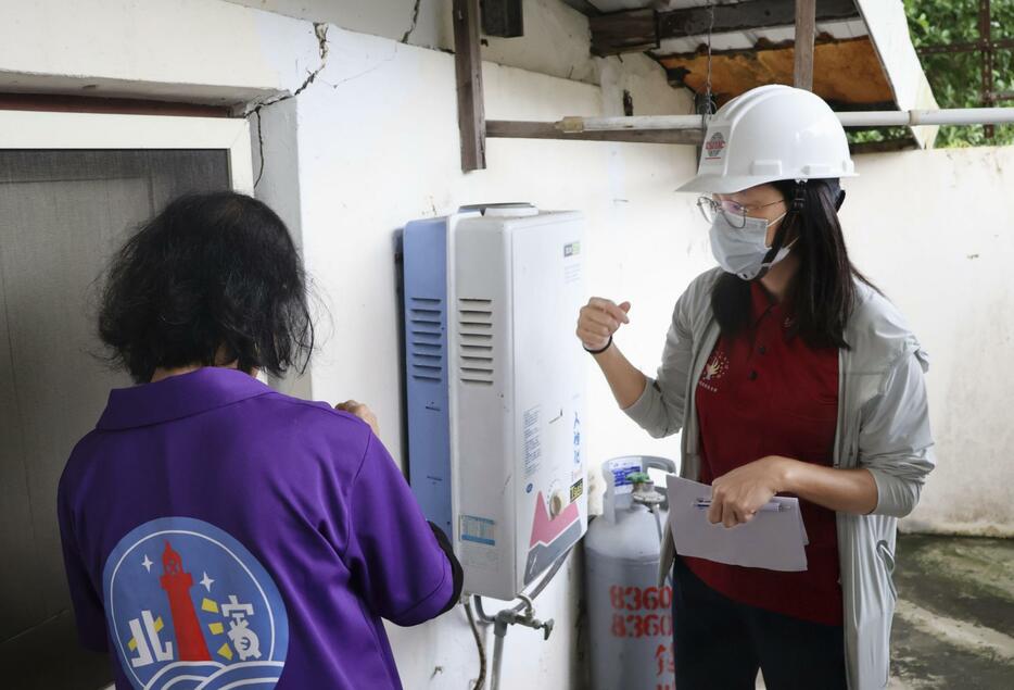 2日、台湾東部・花蓮で住民（左）から家の損傷状況を聴取するTSMCのボランティアの女性（共同）