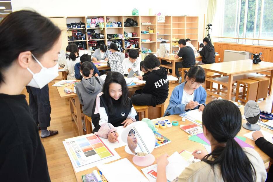 いろいろな紙のコラージュで自画像を作る児童=岡山県真庭市で