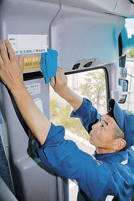 バス運転手の名札入れを取り外す従業員。北陸の企業で、カスハラ対策が広がっている＝金沢市内