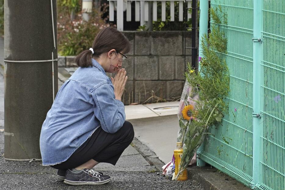 事件現場に花を手向け、手を合わせる近隣住民の岩崎由紀子さん＝28日午前、川崎市多摩区