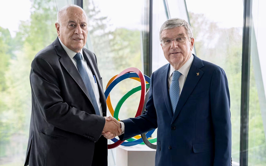 IOCのバッハ会長（右）と握手するパレスチナ・オリンピック委員会のラジューブ会長＝4月、スイス・ローザンヌ（IOC提供）