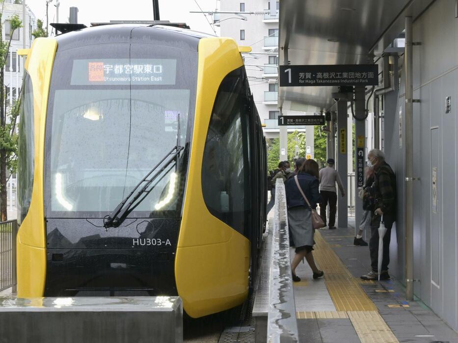 次世代型路面電車（LRT）を乗降する利用者＝13日午後、宇都宮ライトレール宇都宮駅東口停留所