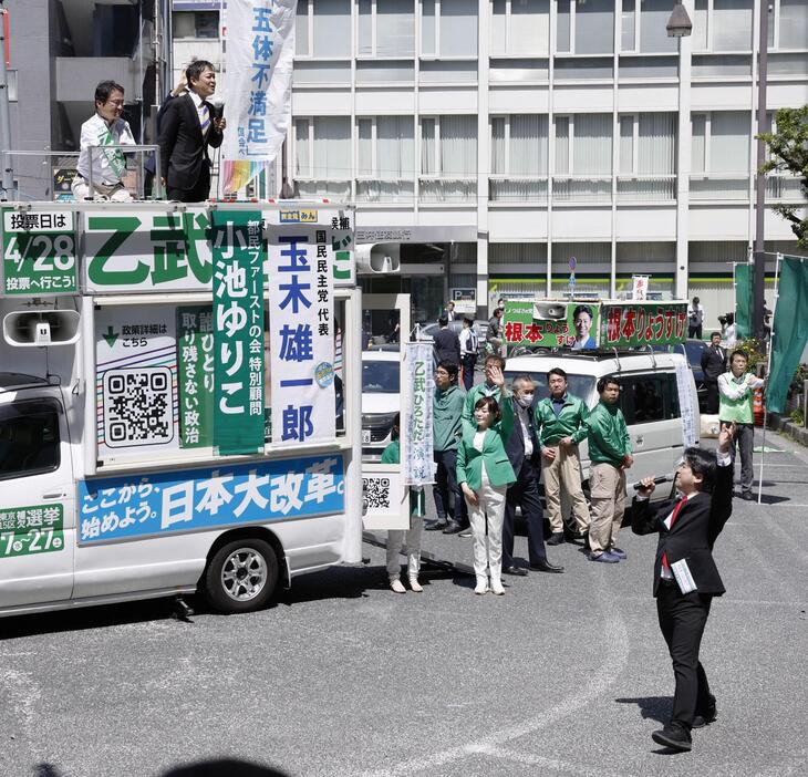 衆院東京15区補欠選挙の告示日、立候補した乙武洋匡氏（左上）の演説会場周辺で声を上げる政治団体「つばさの党」代表（右下）＝4月、東京都江東区