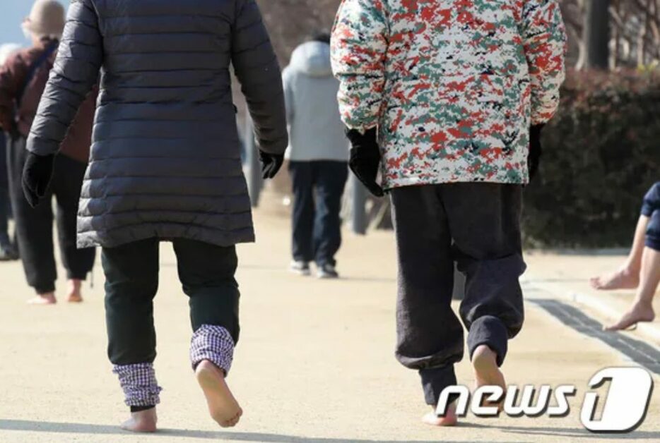 大邱・寿城池を訪れた市民たちが遊歩道に沿って裸足で歩いている(c)news1