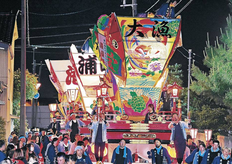 たてもんに明かりをともし勇壮に港町を練る山車＝１７日午後８時半、富山市岩瀬萩浦町