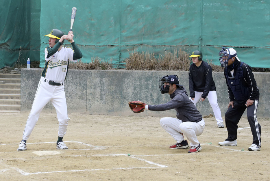 試合でバッターボックスに立つダンデライオンズの選手と、代走のために控える選手（右から2人目）。2024年3月